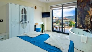 A modern bedroom with a large bed, a bathtub, and a scenic view through the window.