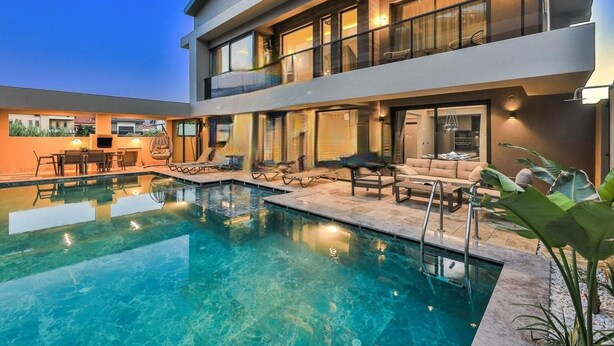A modern two-story house with a swimming pool, outdoor seating, and a balcony. - Zentrale in Fethiye by Interhome (Ölüdeniz)