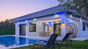 A modern house with a swimming pool, outdoor seating, and a well-lit patio area. - Villa in der Natur by Interhome (Ölüdeniz)