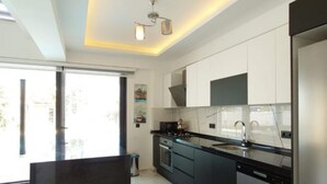 A modern kitchen with white cabinets, a black countertop, and stainless steel appliances. - Villa in Ölüdeniz für Familien 8 P by Interhome (Ölüdeniz)