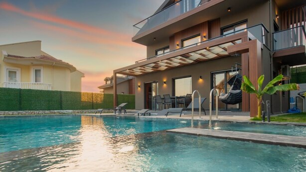 Un área de piscina moderna con vista despejada, sillones de descanso y una escalera que lleva a un nivel superior.