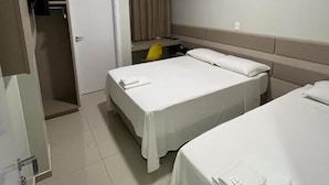 A hotel room with two beds, a television, an air conditioning unit, and a door. - Hotel Catarina (Sao Miguel Do Oeste)