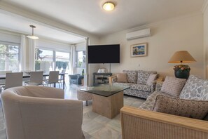A living room with a glass coffee table, patterned sofas, a flat-screen TV, and a lamp. - Villa Marbesa Beach (Marbella)