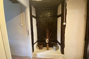 A narrow hallway with a white door on the left and a dark wooden door on the right. - ⭐ 3-Star Countryside Gîte with Pool - 2 bedrooms - Charente countryside (Exideuil-sur-Vienne)