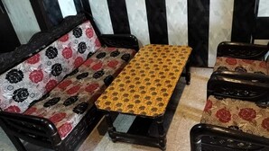 A sofa and a small table with floral upholstery in a room with striped walls.