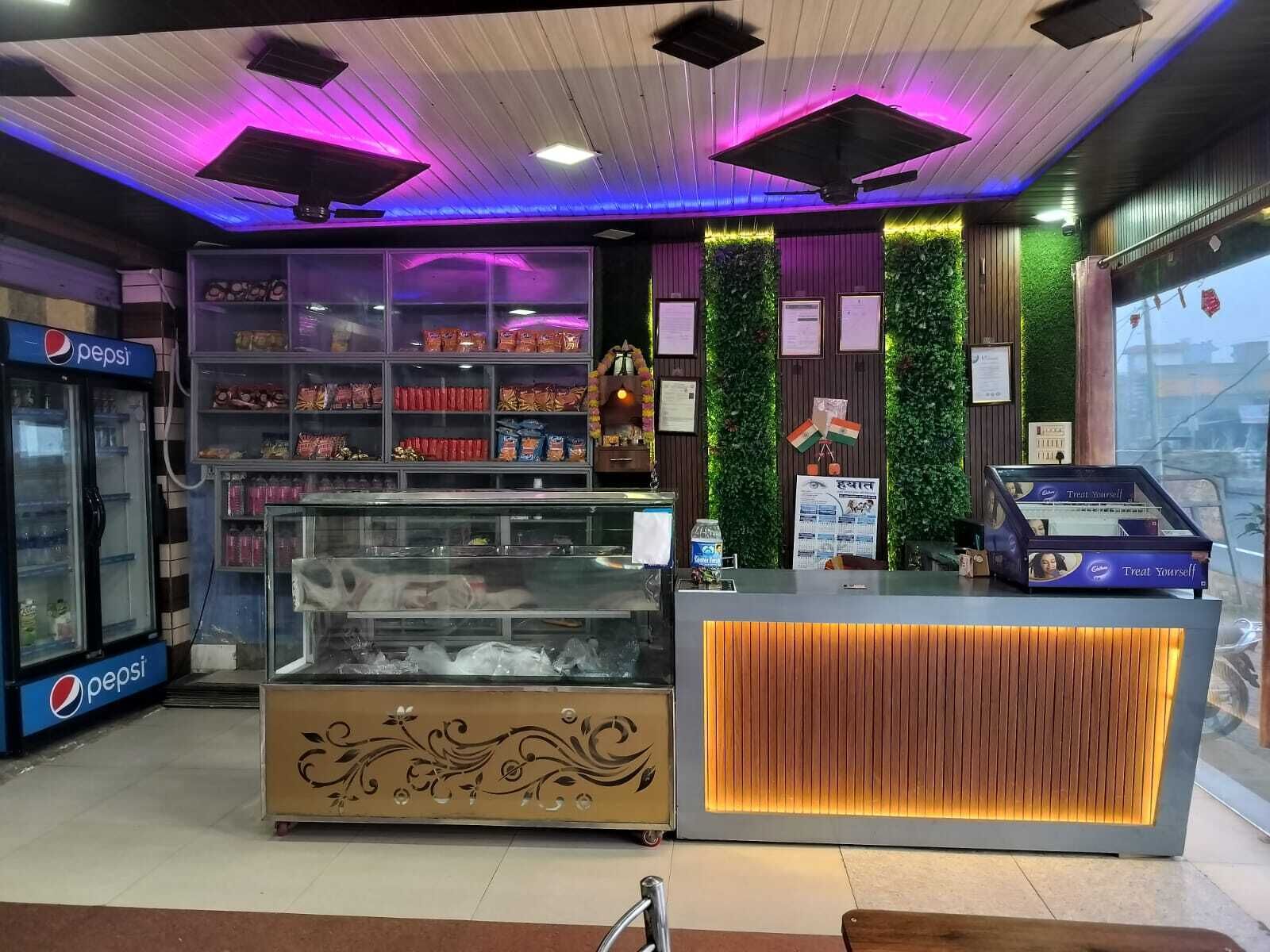 Un mostrador de comida con un diseño decorativo, un refrigerador de Pepsi y una vitrina con bocadillos.