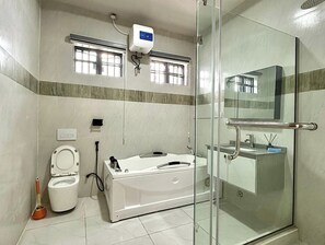 A modern bathroom with a glass shower enclosure, a bathtub, and a toilet. - Yusuf Baba Shortlets (Abuja)