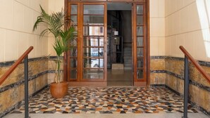 Una escalera con piso estampado que lleva a una puerta de madera con paneles de vidrio.