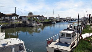 A marina with boats docked, a small building with a roof, and a clear sky. - swimmingpool - Strand - Geschäfte by Interhome (Andernos)