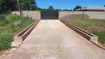 Un sendero de concreto que lleva a una entrada con puerta y bordes de ladrillo.