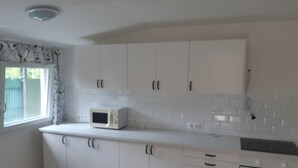 A kitchen with white cabinets, a microwave, and an oven.