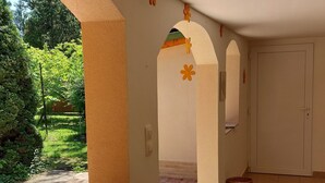 A covered outdoor area with a tiled floor, a door, and a wicker basket. - 100 Meter vom Strand by Interhome (Zamardi)