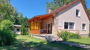 A house with a stone facade, a wooden porch, and a small garden. - 100 Meter vom Strand by Interhome (Zamardi)