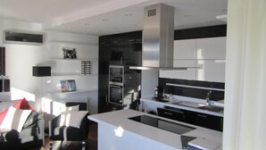 A modern kitchen with a central island, built-in appliances, and a sleek design. - Penthouse mit Donaublick by Interhome (Budapest)