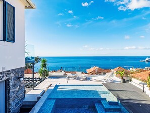 Ein Pool auf dem Dach mit Blick auf das Meer und eine Yacht.