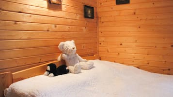 A cozy room with wooden walls and a plush white carpet.