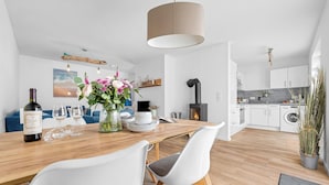 Une cuisine moderne avec des armoires blanches, un four encastré et une cuisinière.