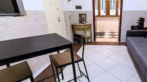 A compact living space with a dining table, two chairs, a sofa, and a small side table. - Dimora Mira - Downtown Bari (Bari)