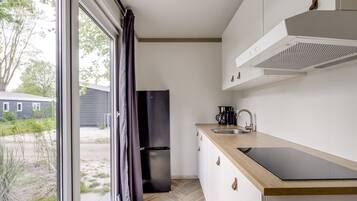 A modern kitchen with a large window, a built-in oven, and a sink.