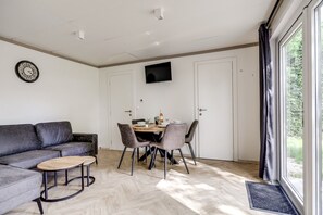 Ein stilvolles Wohnzimmer mit einer Couch, einem Couchtisch und einem Esstisch mit Stühlen.