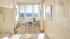 A bedroom with a bed, a desk, and a view of the sea. - Strandkieker - Cozy apartment with sea view (List auf Sylt)