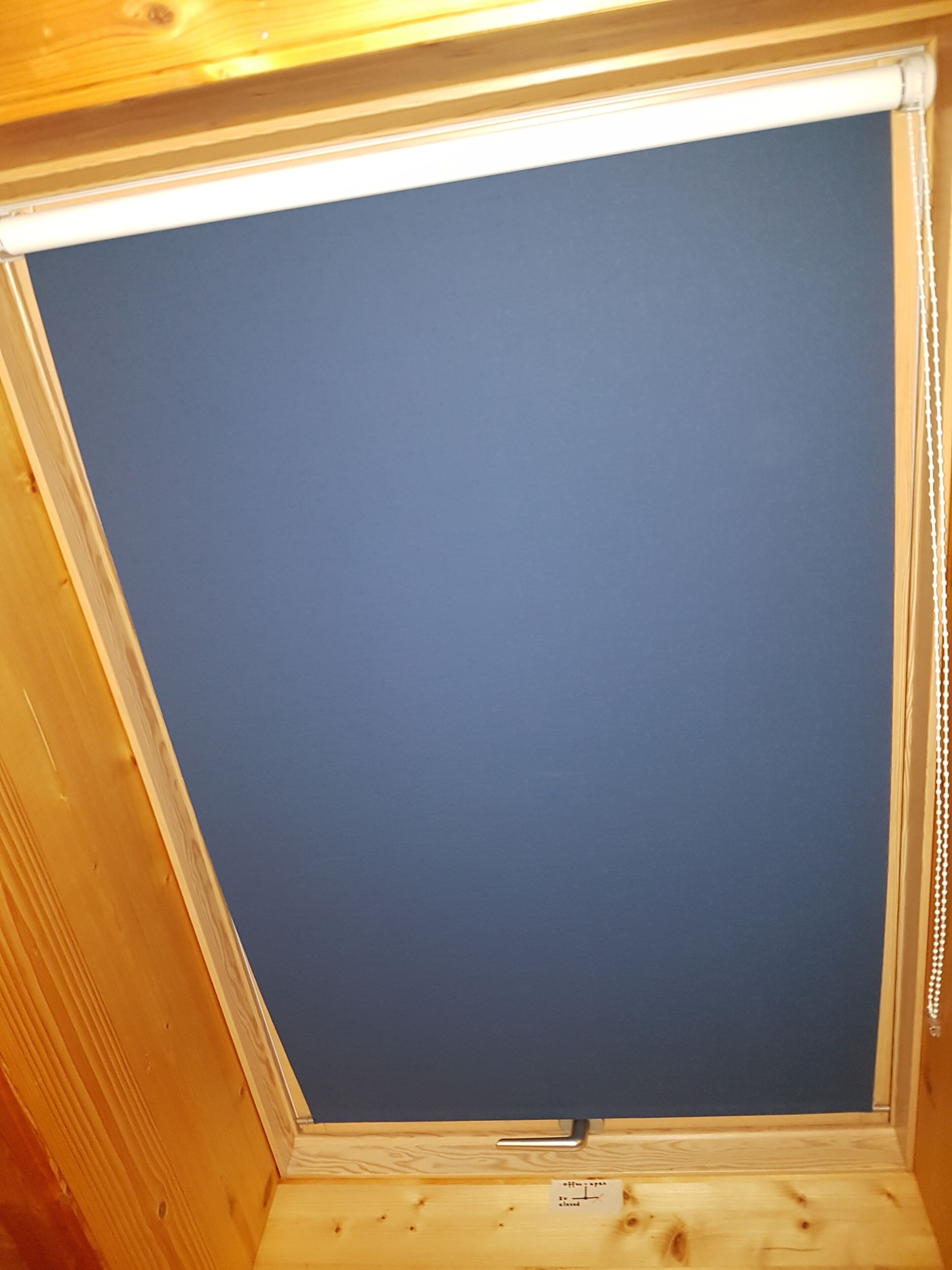 Une pièce avec un plafond en bois et un mur bleu.