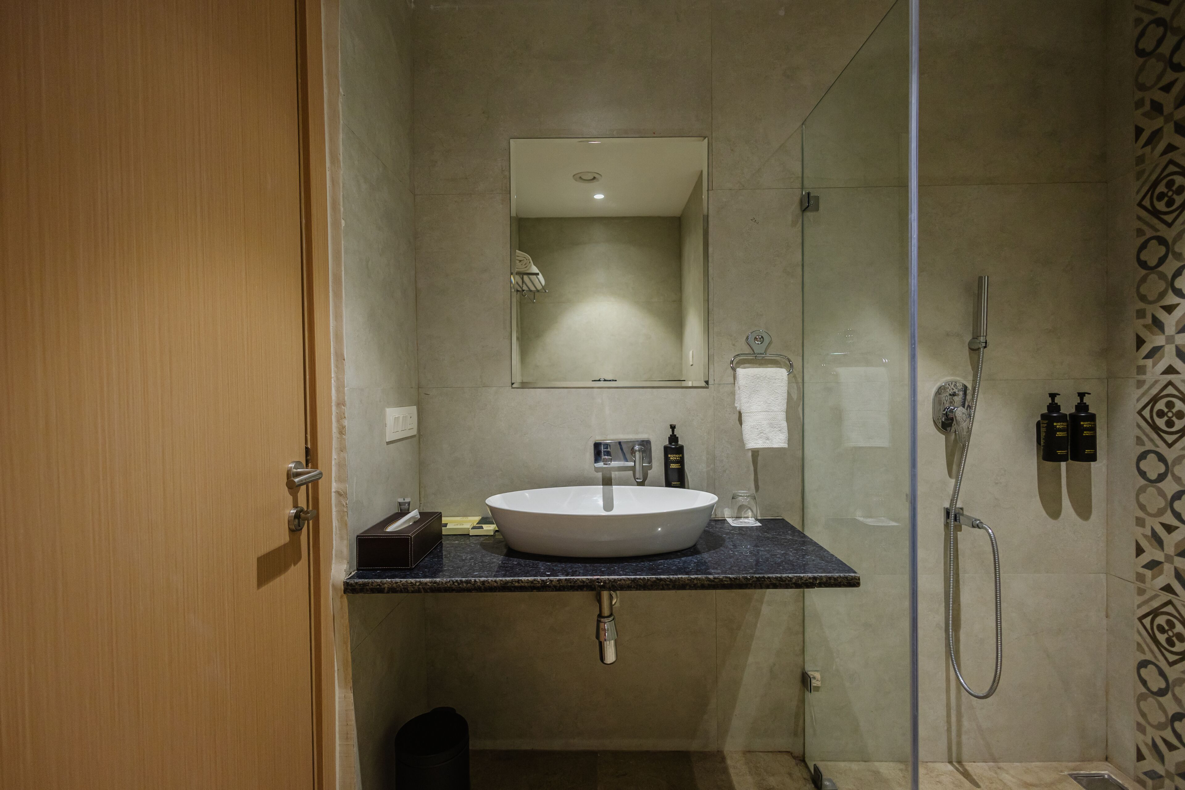 A modern bathroom with a large sink, mirror, and shower.