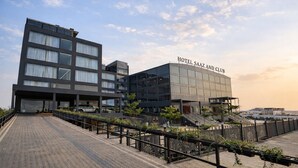 A modern hotel with a flat roof, large windows, and a sign reading 'HOTEL SAAZ AND CLUB'. - Saaz Hotel, Club & Convention Centre (Indore)