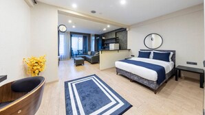 A modern hotel room with a large bed, a desk, a chair, and a small kitchenette. - the business class suit karkoy (Istanbul)