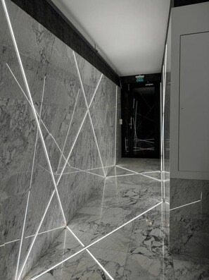 A modern hallway with marble walls and floors, featuring geometric light patterns. - the business class suit karkoy (Istanbul)