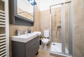 Un bagno moderno dotato di doccia, toilette e lavandino.