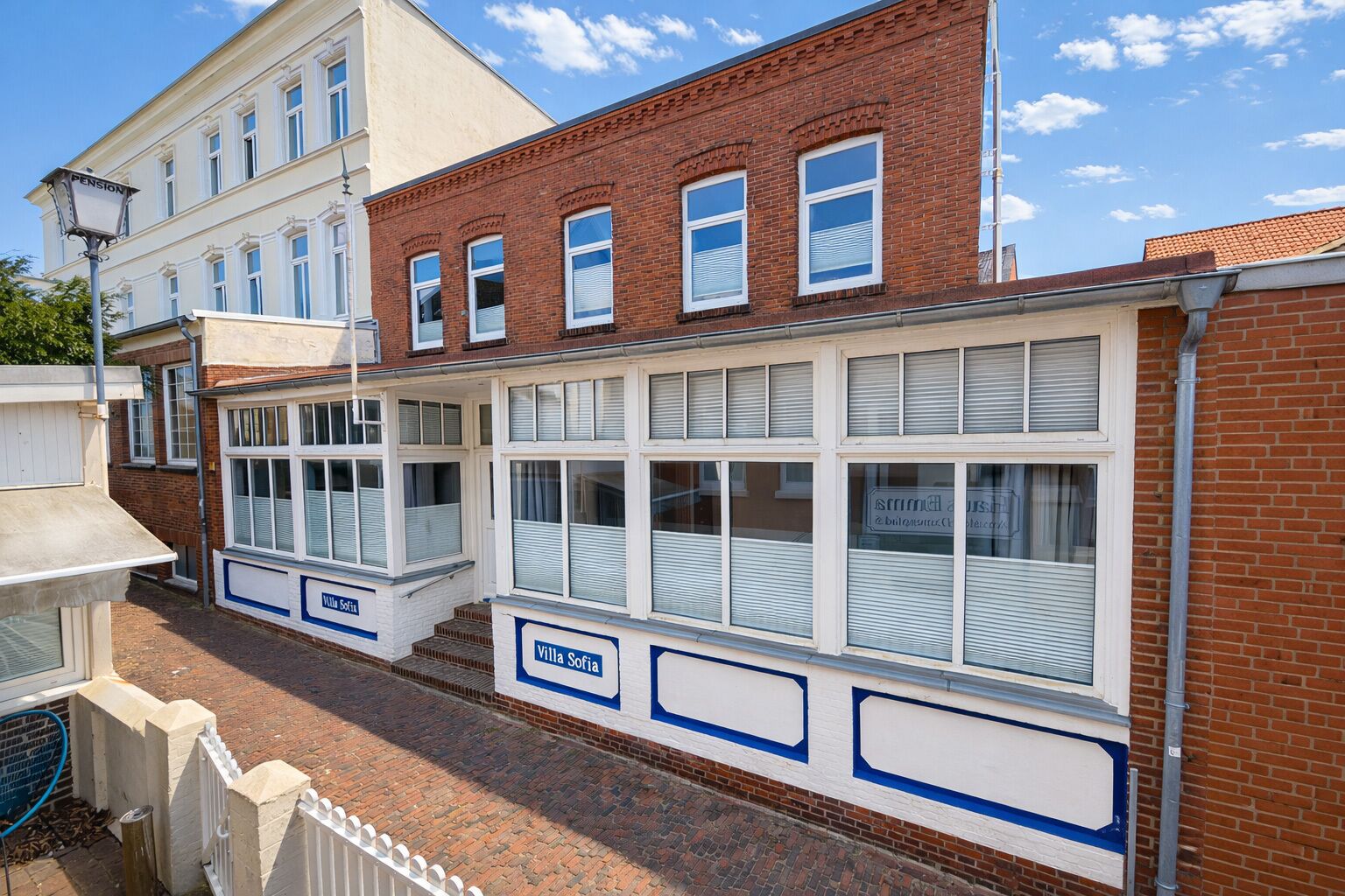 Un edificio con fachada blanca, varias ventanas y un cartel que indica 'Villa Sofia'.