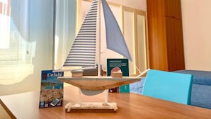 A model sailboat on a table, a book titled "PIRANDELLO" beside it, and a blue chair in the background. - Cefalù Pirandello House, very spacious facility, close to the sea and the center (Cefalù)