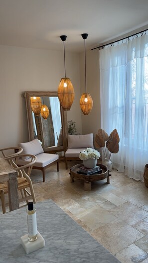 A modern living room with a sofa, chairs, a coffee table, and a large mirror. - Bright, elegant apartment ideally located in the heart of downtown. (Lorgues)