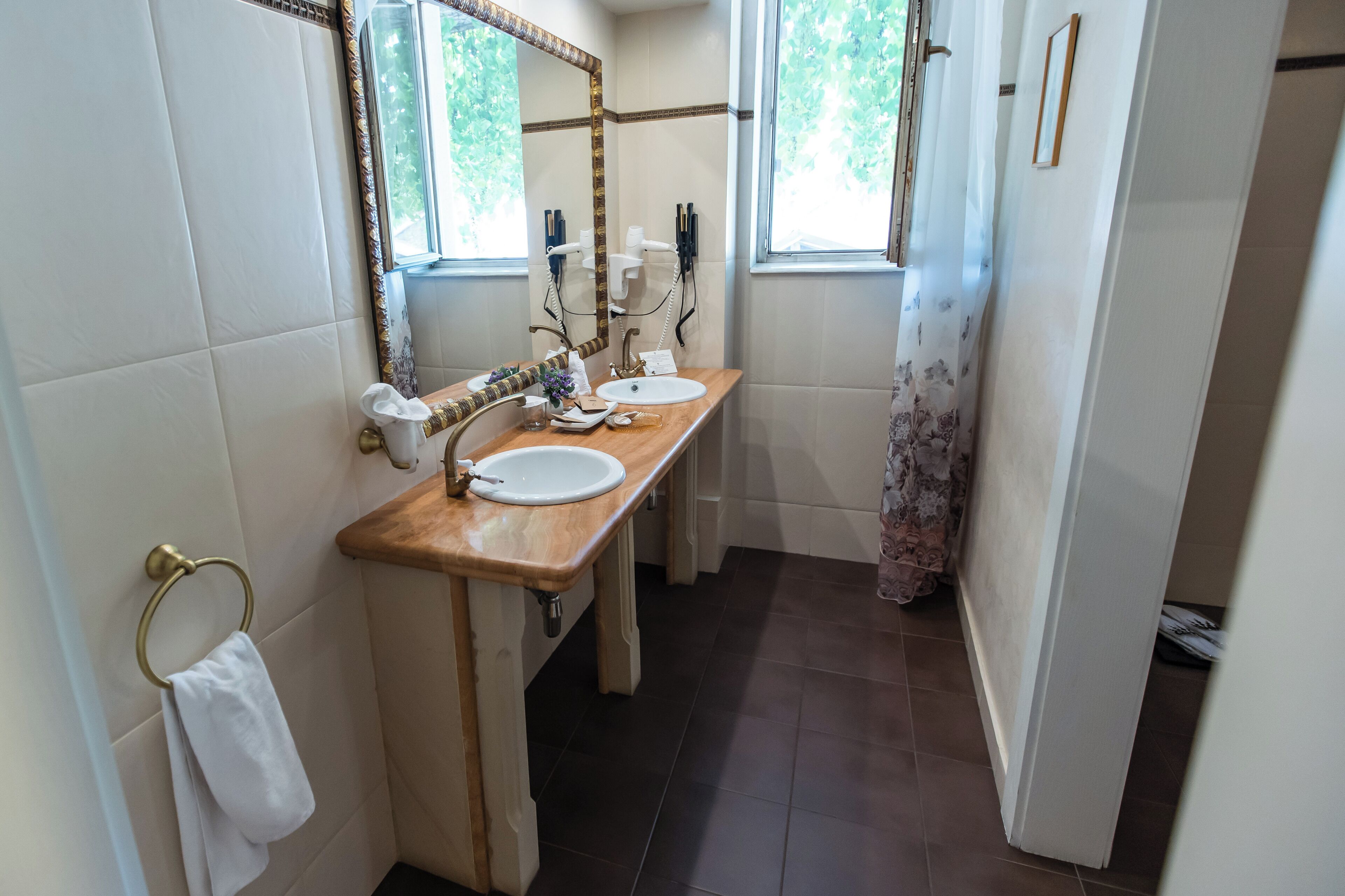 Une salle de bain avec deux lavabos, un miroir et un porte-serviettes.