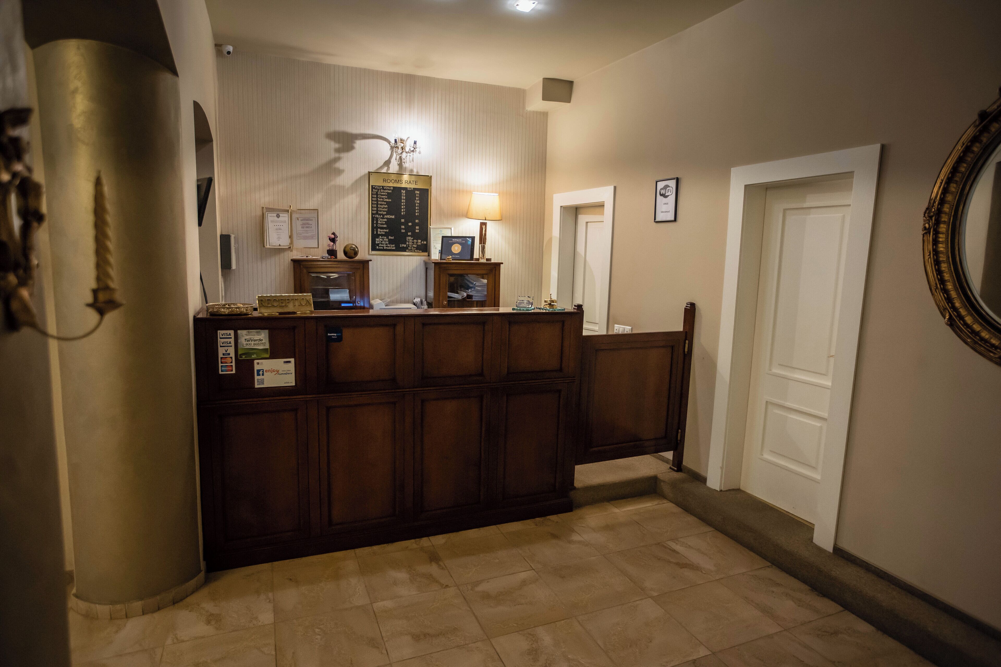 A reception desk with a bulletin board, a lamp, and a framed certificate.