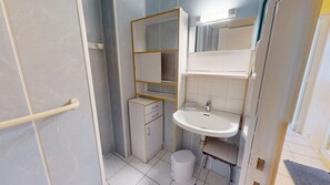 A compact bathroom with a white sink, a toilet, and a small storage cabinet. - Studio des Nénuphars - Beach 500m away & terrace (Saint-Hilaire-de-Riez)