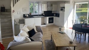 Ein modernes Wohnzimmer mit Sofa, Couchtisch und Essbereich.