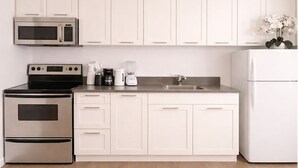 A modern kitchen with white cabinets, a stainless steel oven, a microwave, a coffee maker, and a blender. - Coastal Retreat Charming 1bdr MiamiBeach (Miami Beach)
