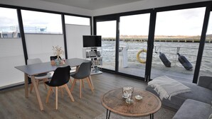 Ein modernes Interieur mit Essbereich, Sofa und Blick auf das Wasser.