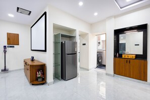 A modern kitchen with a built-in refrigerator, a wooden cabinet, and a washing machine.