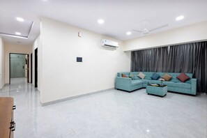 A modern living room with a sectional sofa, a coffee table, and a ceiling fan.