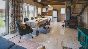 Un grand espace de vie comprenant une table à manger, des chaises, un canapé et une cheminée.