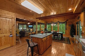 L’intérieur d’un chalet en bois comprend une cuisine, un coin repas et un salon.