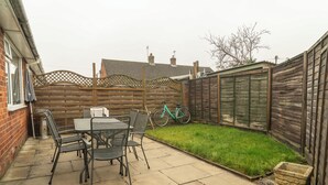 A patio area with a table and chairs, a bicycle, and a small grassy patch. - No 48 - 3 Bedroom Heworth in York (York)