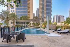 A rooftop pool area with lounge chairs, a table, and a pool. - A Free Housekeeping Visit FOR Every Stay Between THE 16th FEB AND THE 16th MAR - Stayshort - 1 Bed in Downtown Dubai That Sleeps 4 With Balcony (Dubai)