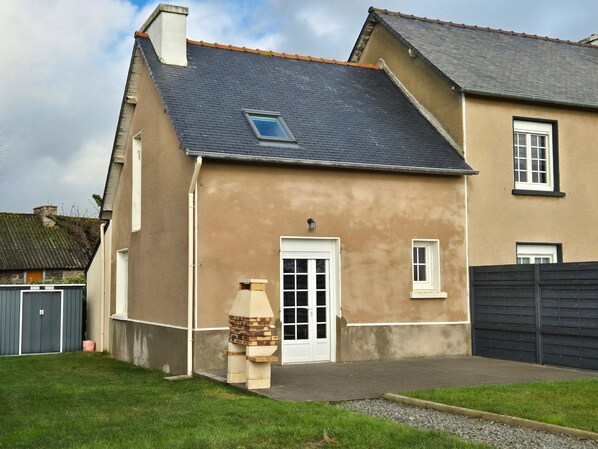 A two-story house with a grey roof, a small window, and a white door. - Terraced Country House Near Sea (Plurien)