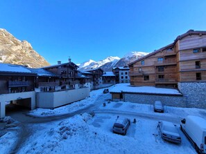 A snow-covered village with wooden buildings and a mountain backdrop. - Val d'Isère - 3-room apartment, 6 pers, pets allowed (Val-d'Isère)