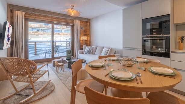 A modern kitchen with a dining area, wooden furniture, and a view of a snowy landscape. - Elegant apartment at the foot of the slopes, Alpe d'Huez (Huez)