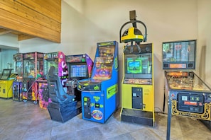A row of arcade machines in a room with wooden ceiling beams and tiled flooring. - 4 Mi to Slopes! Breck Mtn Base w/ Hot Tub Access (Breckenridge)
